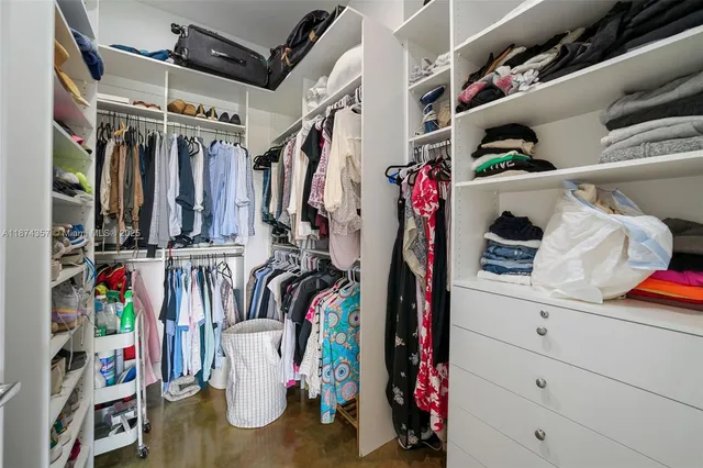 a view of walk in closet with clothes