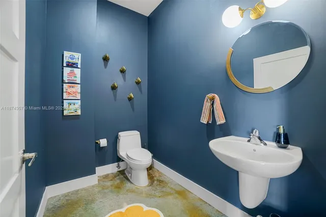 a bathroom with a toilet sink and mirror