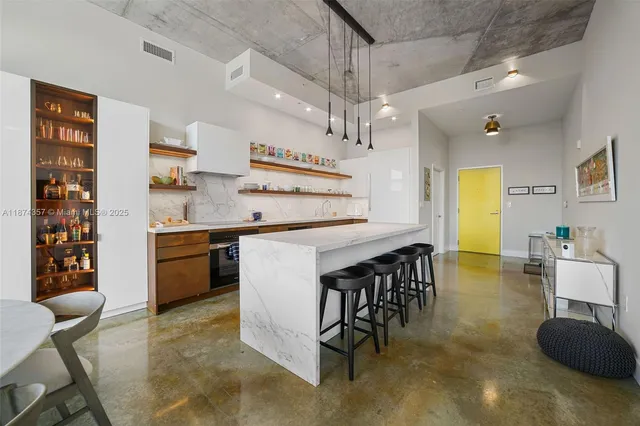 a kitchen with stainless steel appliances granite countertop a sink a stove and a dining table