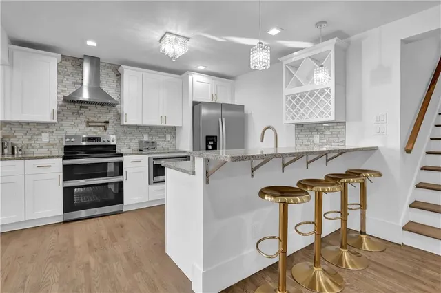 a kitchen with kitchen island stainless steel appliances a stove refrigerator sink and microwave