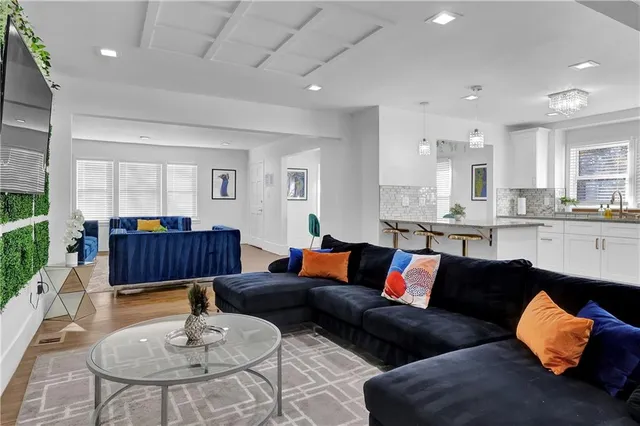 a living room with furniture and kitchen view