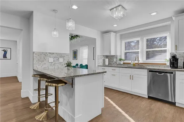 a kitchen with granite countertop a sink a counter space appliances and cabinets