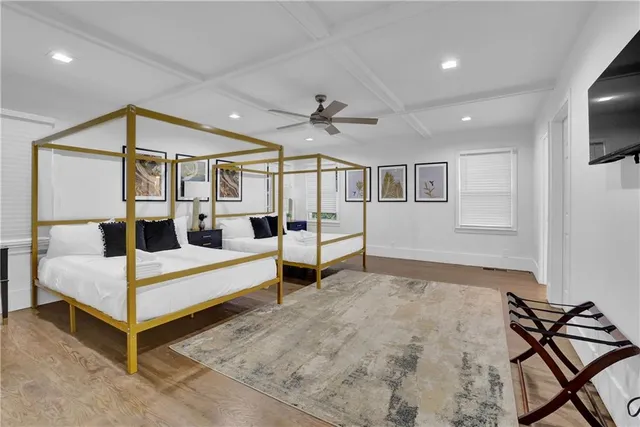 a spacious bedroom with a bed and a flat screen tv