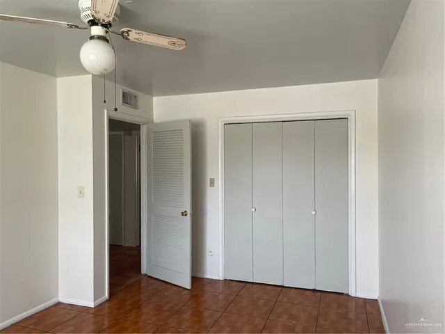 a view of an empty room with a chandelier fan