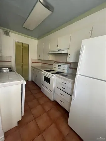 a kitchen with cabinets appliances and a counter space
