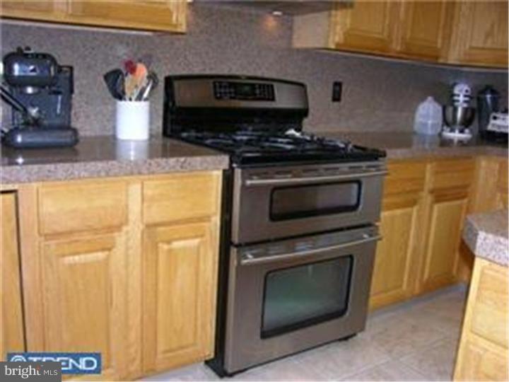 5 Coburn Road Pennington, NJ 08534 - Photo 9 of 25 a kitchen with stainless steel appliances wooden cabinets and a stove top oven