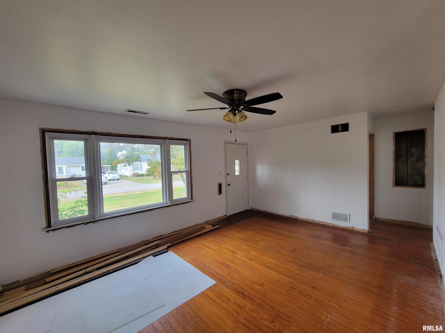 225 Hickory Street Flora, IL 62839 - Photo 13 of 56 an empty room with wooden floor and windows