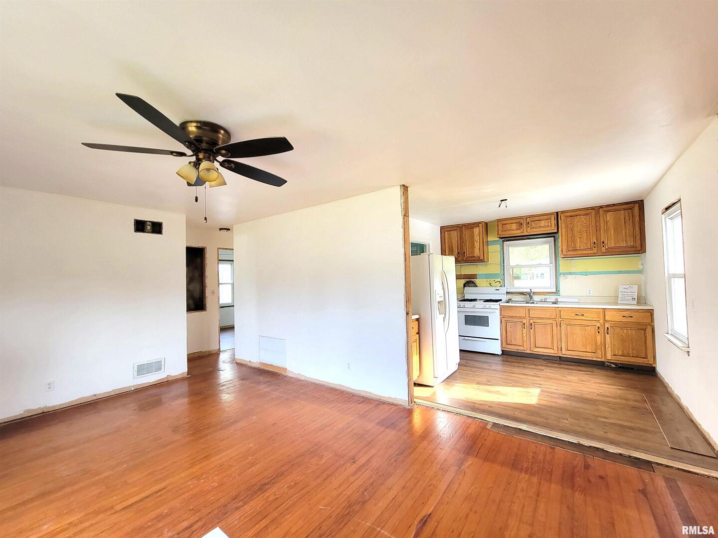 225 Hickory Street Flora, IL 62839 - Photo 25 of 56 a view of a big room with wooden floor and a ceiling fan