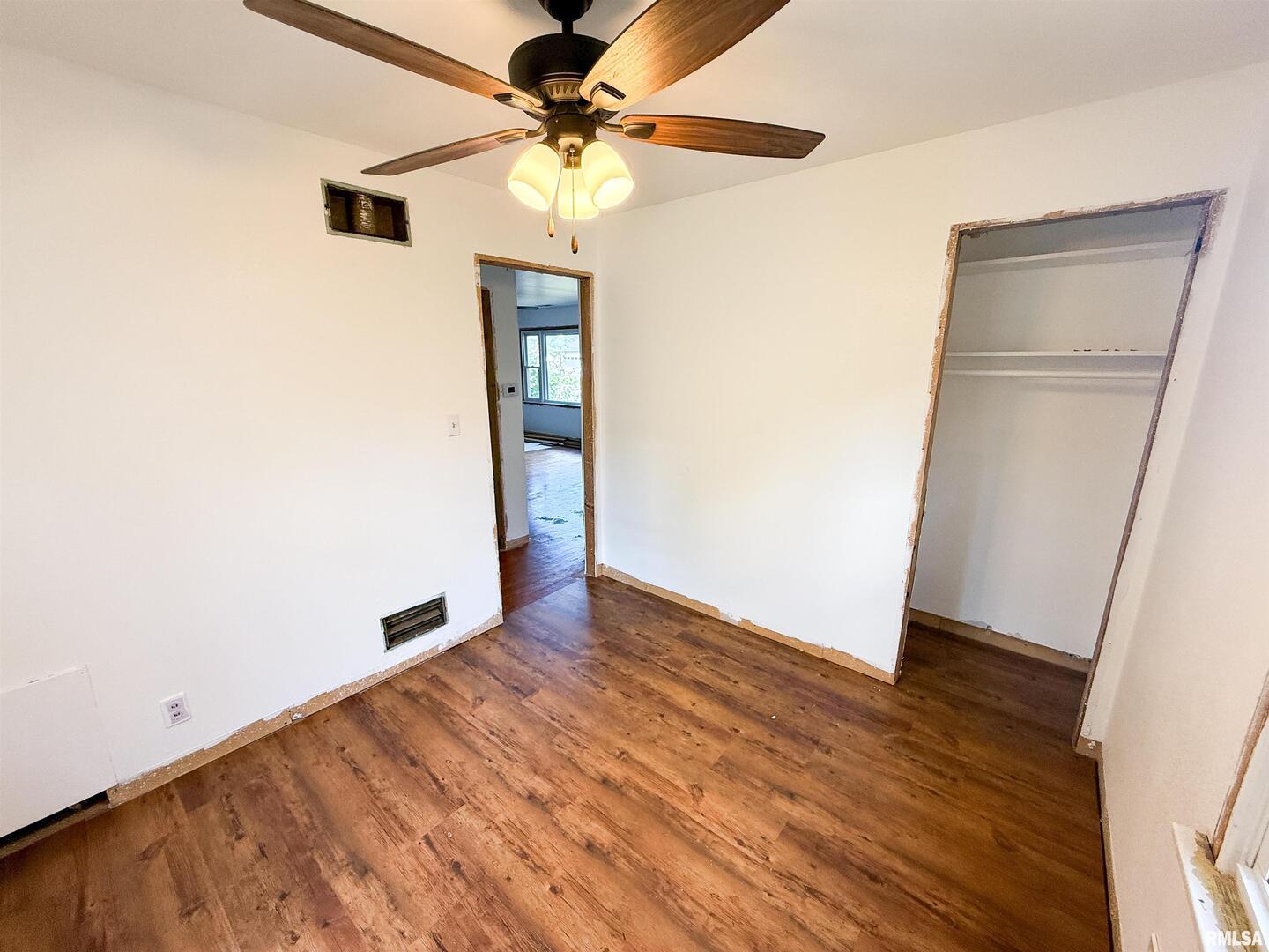 225 Hickory Street Flora, IL 62839 - Photo 4 of 56 an empty room with wooden floor fan and windows
