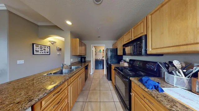 a kitchen with stainless steel appliances granite countertop a stove a sink and a microwave