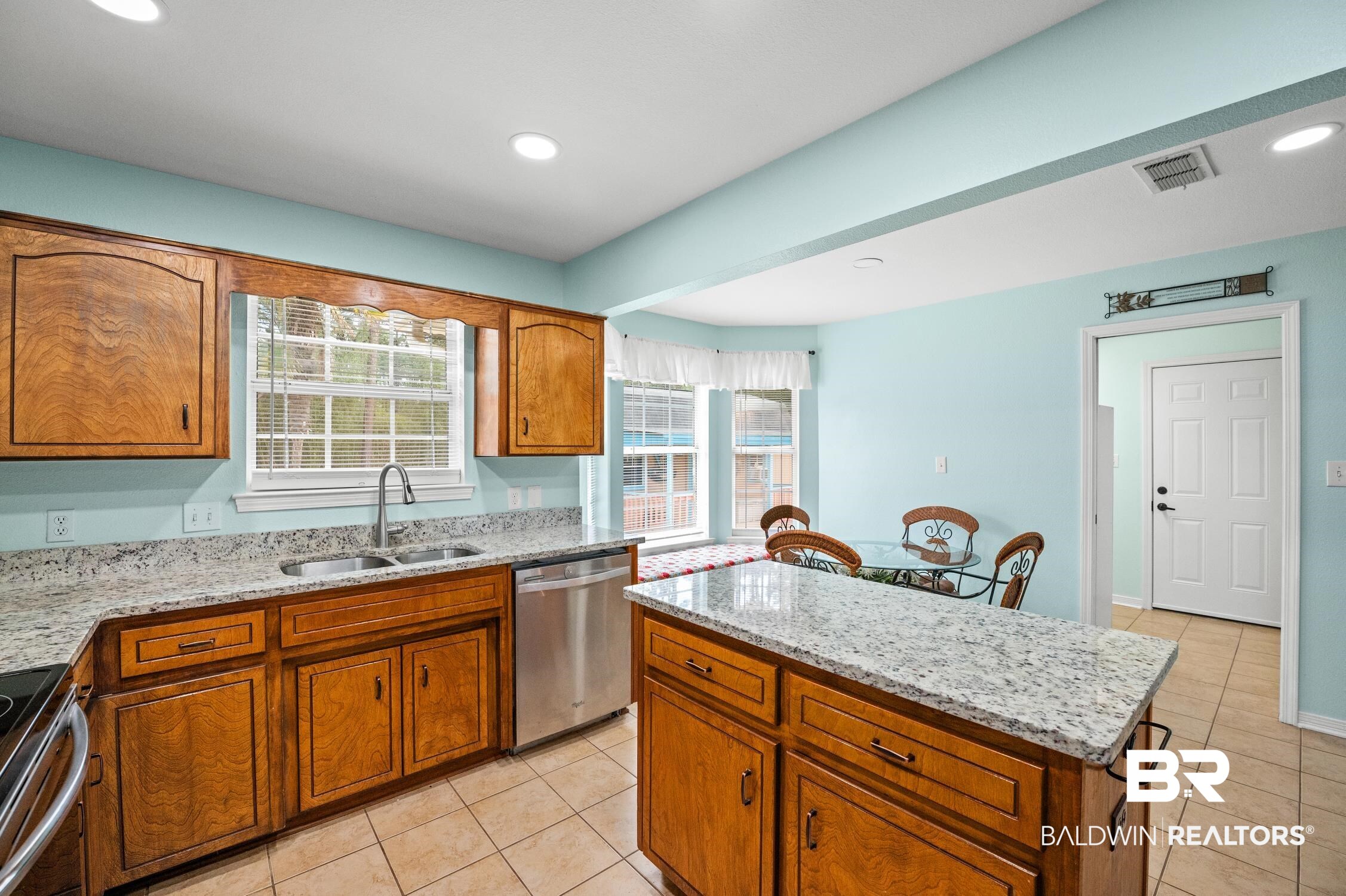 2553 Santa Rosa Drive Lillian, AL 36549 - Photo 15 of 51 Kitchen with a sink, visible vents, a center island, appliances with stainless steel finishes, and brown cabinets