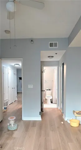a view of a hallway with wooden floor and a living room