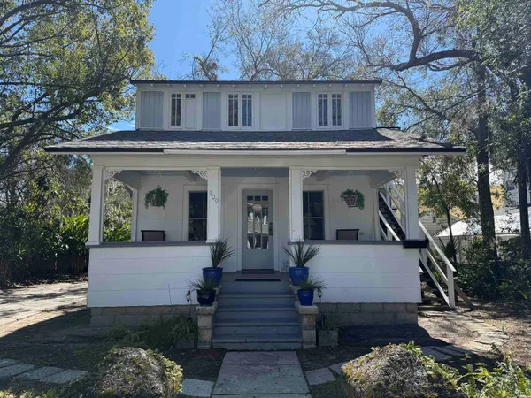 a view of a house with a yard and furniture
