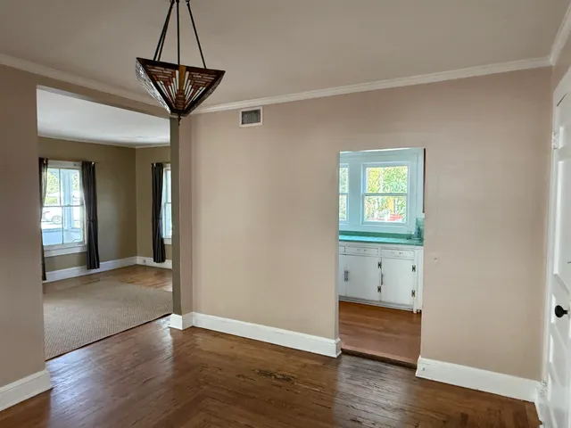 a view of empty room with wooden floor and window