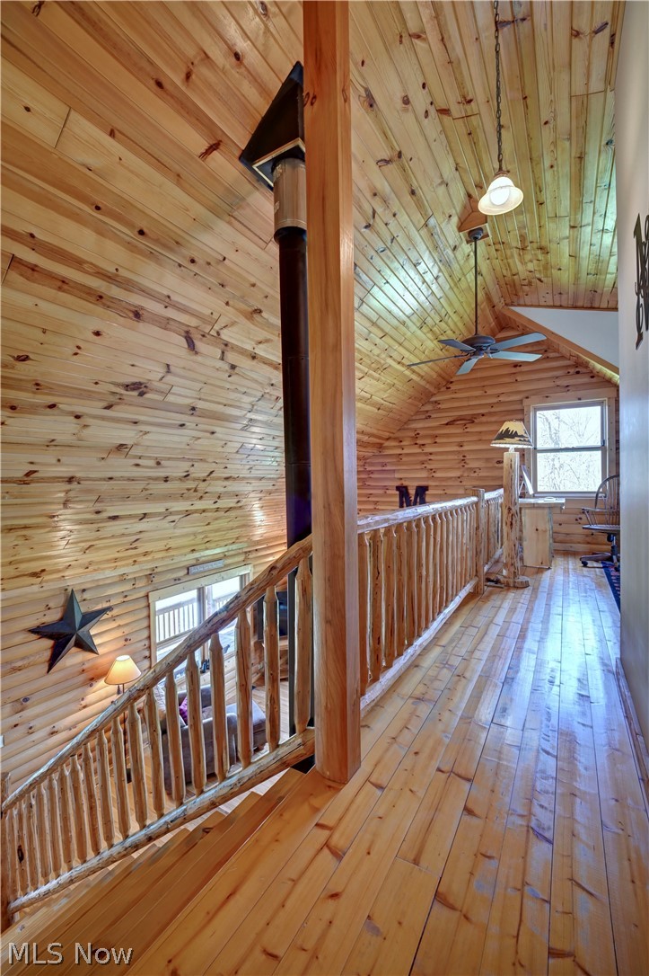 8045 McFadden Road Shreve, OH 44676 - Photo 35 of 45 Hallway featuring a vaulted wooden ceiling, an upstairs landing, wooden walls, and light wood-type flooring