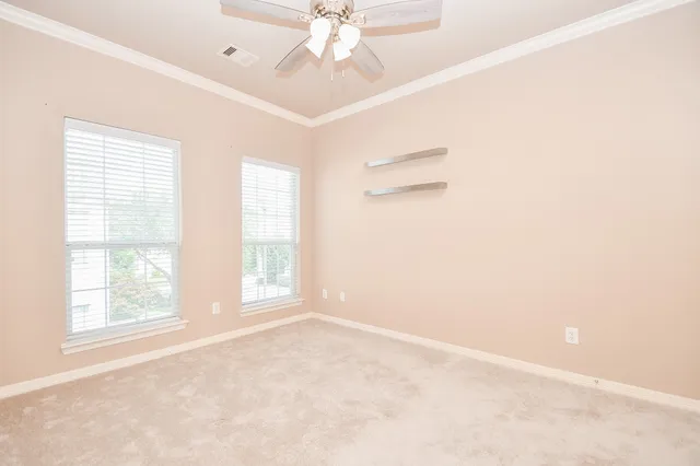 an empty room with windows and fan