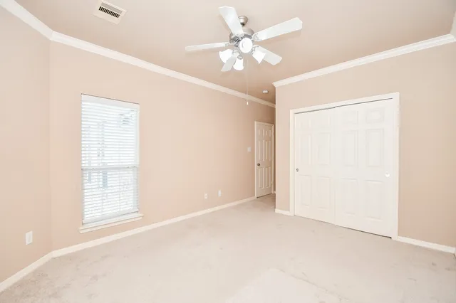 an empty room with windows and fan