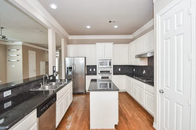 a kitchen with stainless steel appliances a sink and a refrigerator