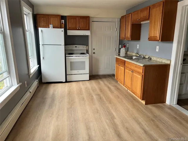 a kitchen with a refrigerator stove top oven and sink