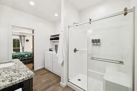 a bathroom with a granite countertop sink toilet and shower