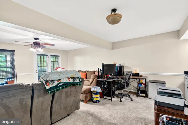 a view of a workspace with furniture and a window