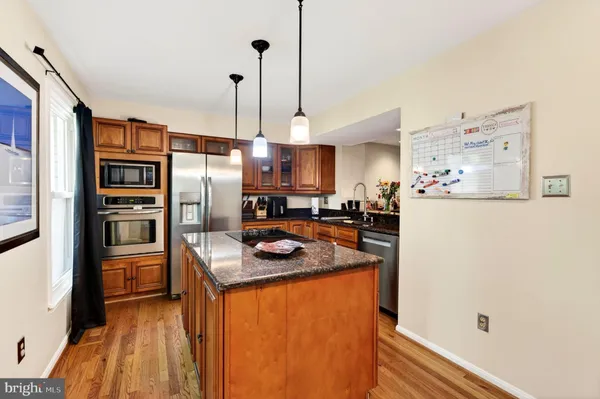 a kitchen with stainless steel appliances granite countertop a refrigerator a oven and a sink