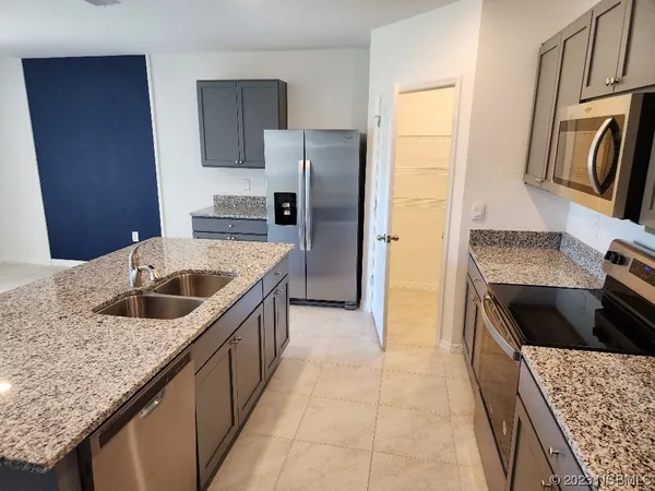 a kitchen with granite countertop a sink stove and refrigerator