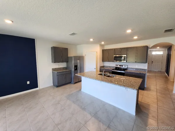 a large kitchen with stainless steel appliances lots of counter top space cabinets and a sink