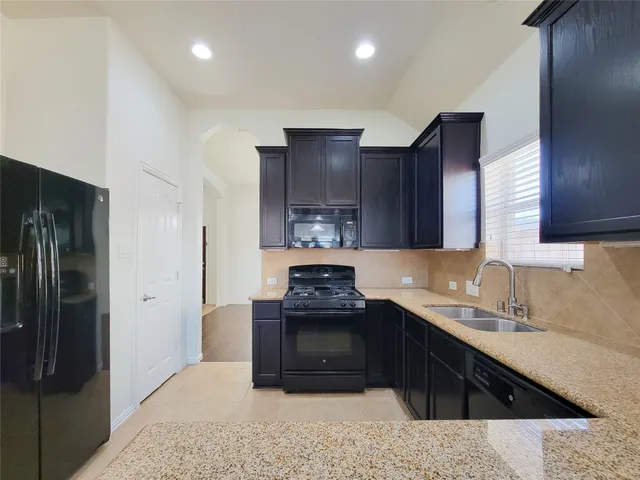 a kitchen with a sink stove and refrigerator