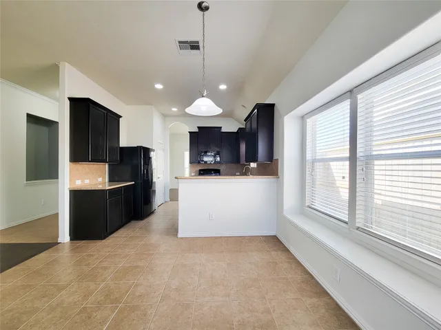 a large kitchen with a large counter top appliances and cabinets