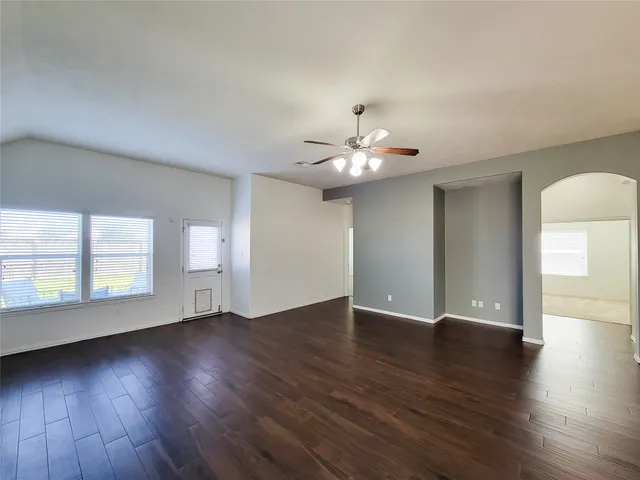 an empty room with a window and a fan
