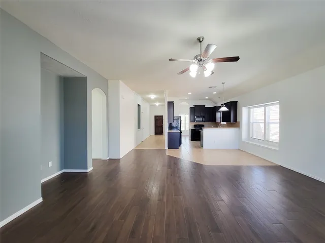 a view of a kitchen with wooden floor and a ceiling fan