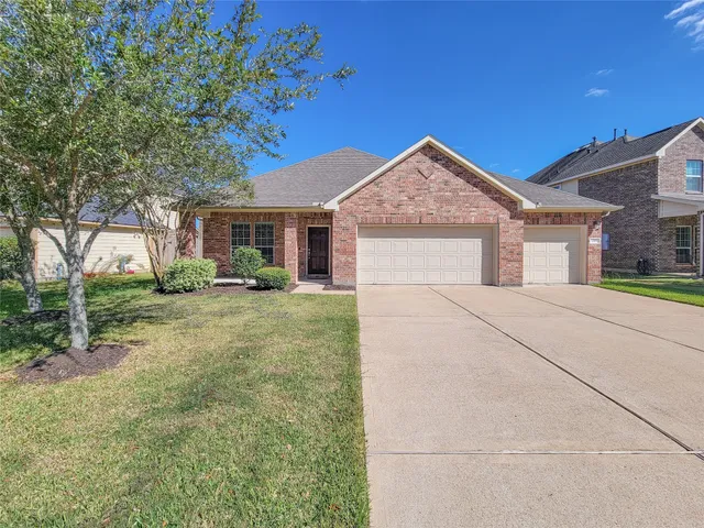 a view of a house with backyard and trees