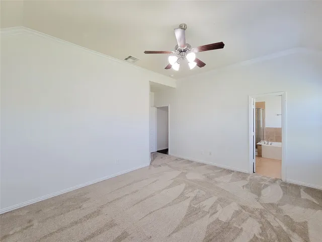 an empty room with a window and a ceiling fan