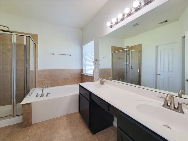 a bathroom with a tub double sink and mirror