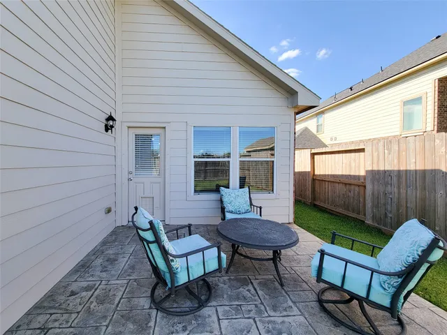 a view of a backyard with table and chairs and a barbeque