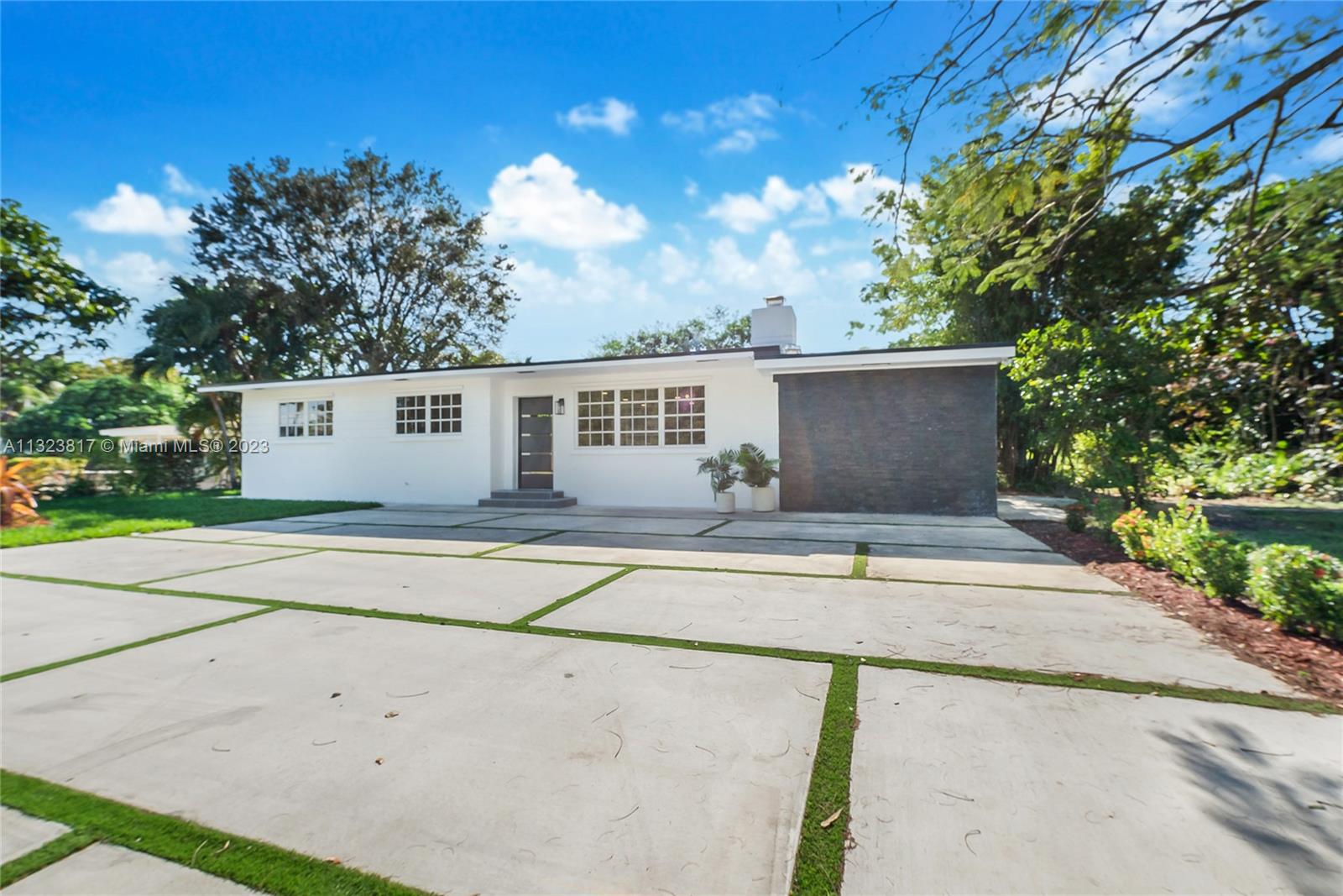8540 Southwest 124th Street Miami, FL 33156 - Photo 17 of 22 a view of a house with a backyard and a garage