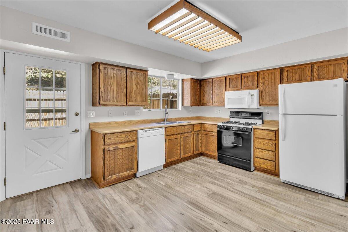 345 South Virginia Street, Unit 9 Prescott, AZ 86303 - Photo 12 of 33 a kitchen with a white cabinets a sink a window and stainless steel appliances
