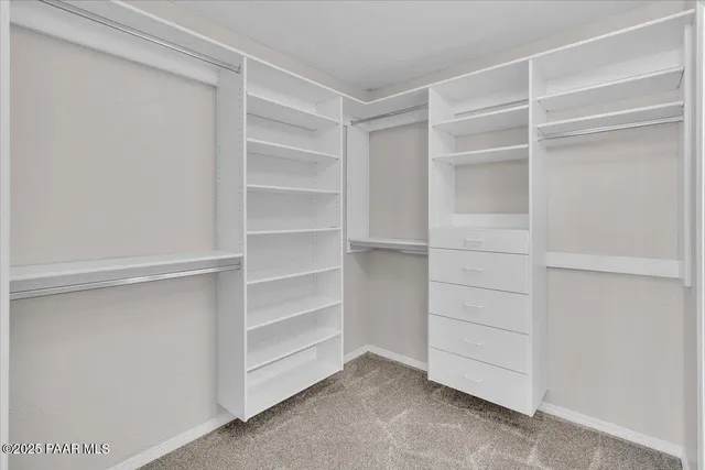 a view of walk in closet with empty racks