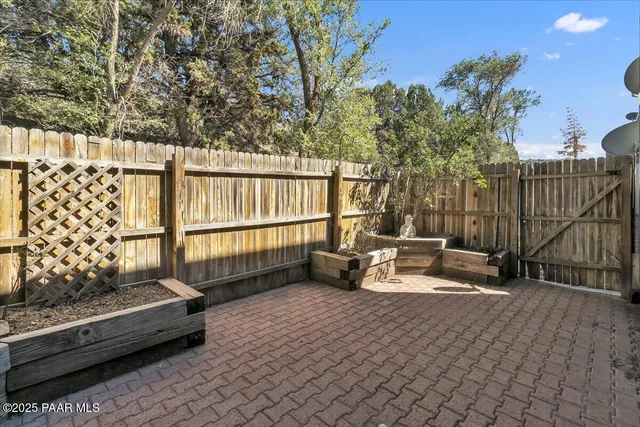 a view of a roof deck with couches and wooden fence