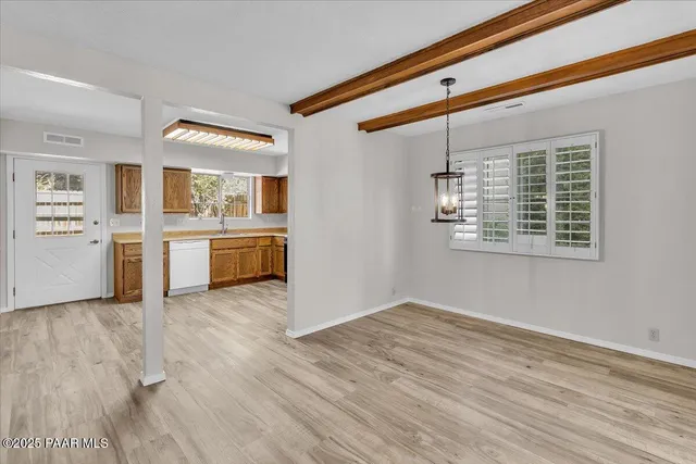 a view of a kitchen with wooden floor and a window