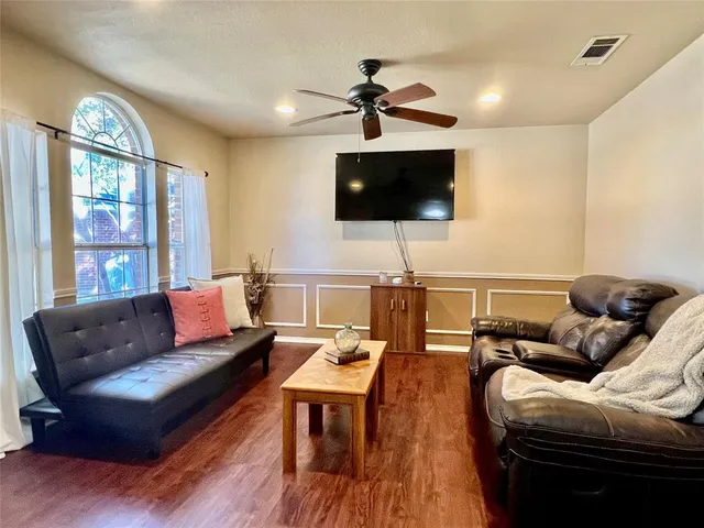 a living room with furniture a flat screen tv and a large window