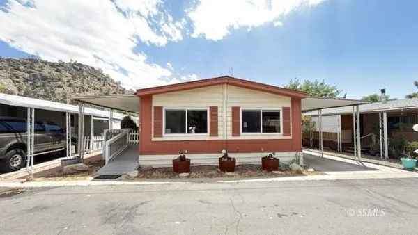 a front view of a house with glass windows and seating space
