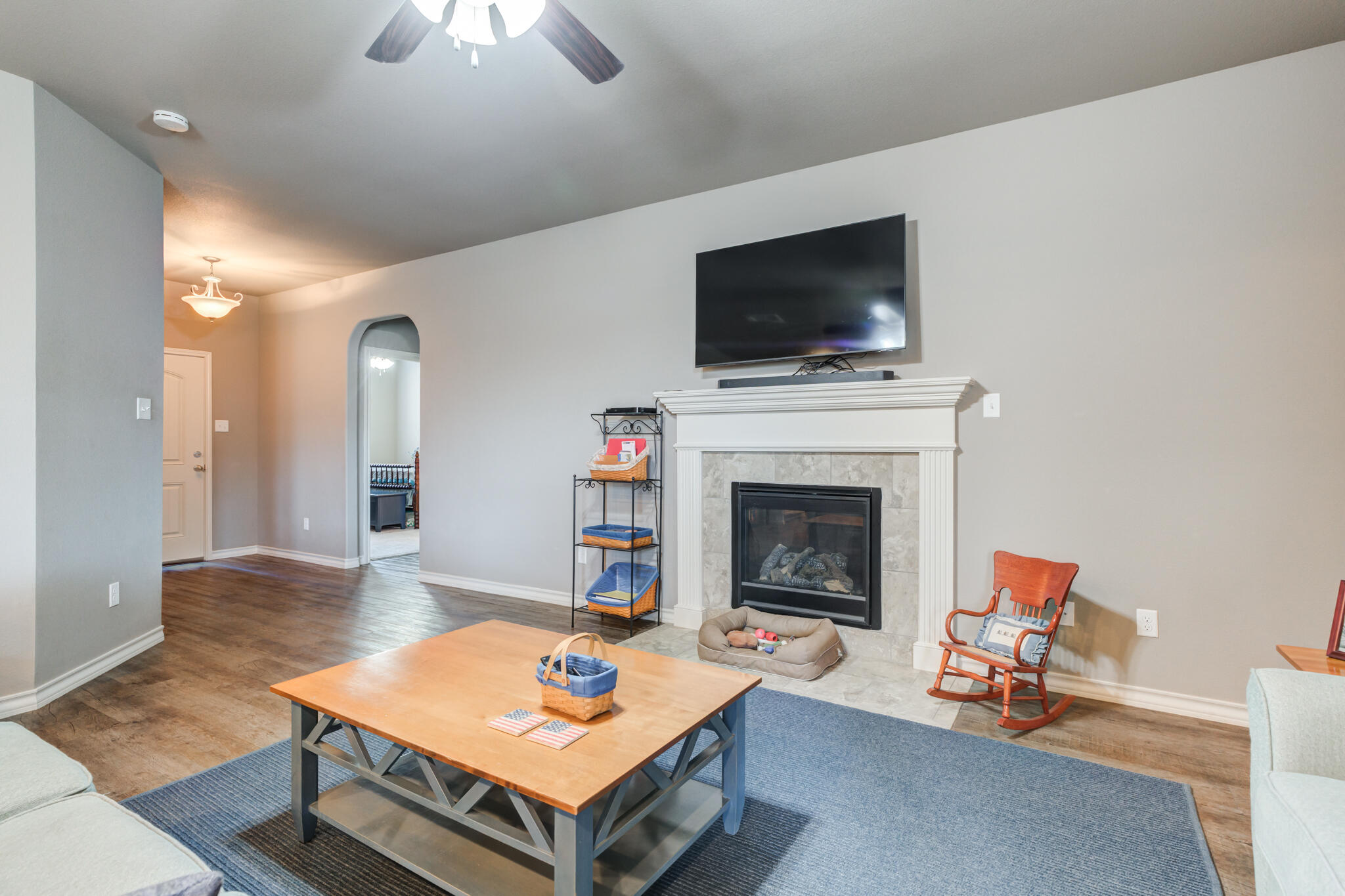 5219 Kemper Street Lubbock, TX 79416 - Photo 12 of 38 a living room with furniture a flat screen tv and a fireplace