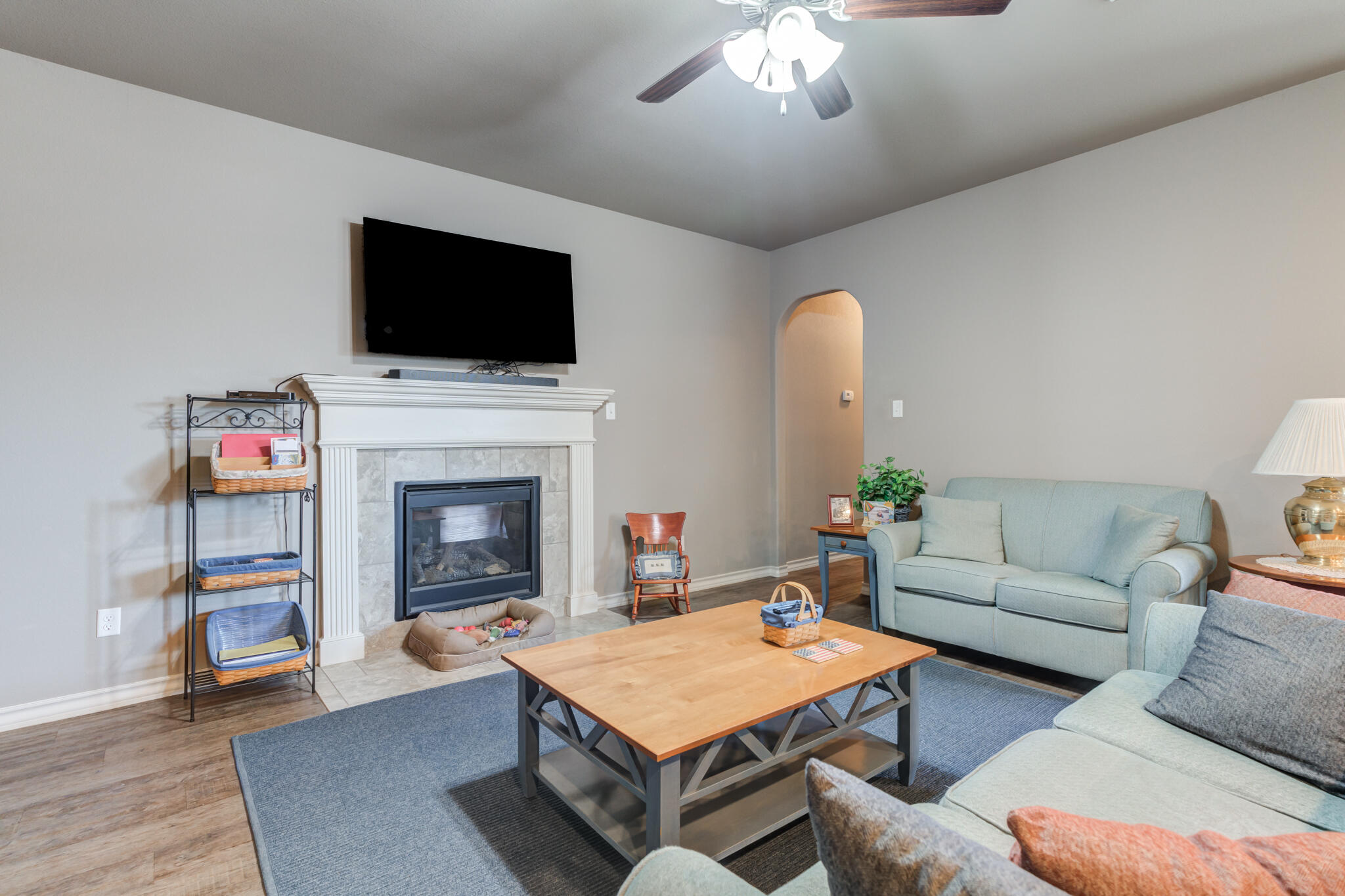 5219 Kemper Street Lubbock, TX 79416 - Photo 2 of 38 a living room with furniture a flat screen tv and a fireplace