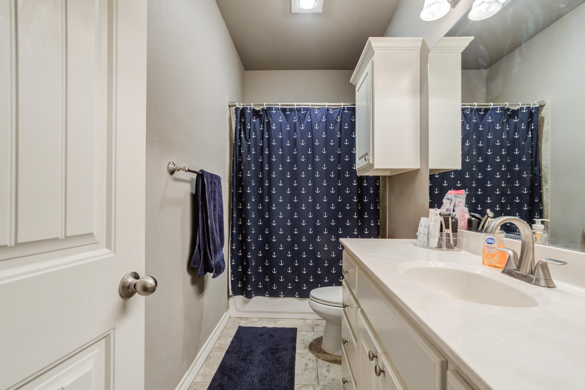 5219 Kemper Street Lubbock, TX 79416 - Photo 31 of 38 a bathroom with a sink a toilet and shower