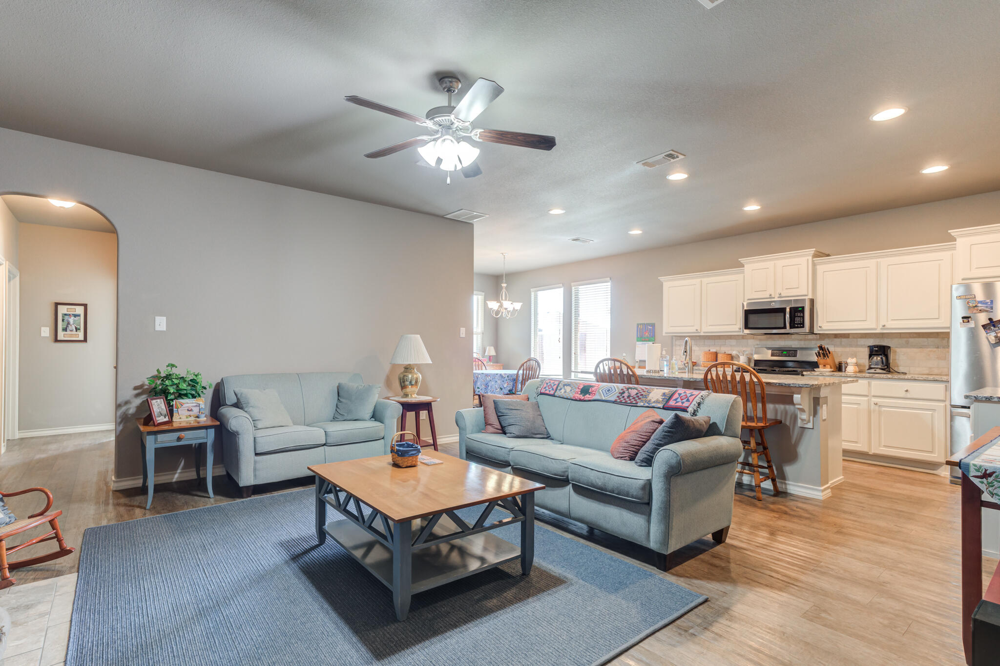 5219 Kemper Street Lubbock, TX 79416 - Photo 9 of 38 a living room with furniture kitchen view and a chandelier