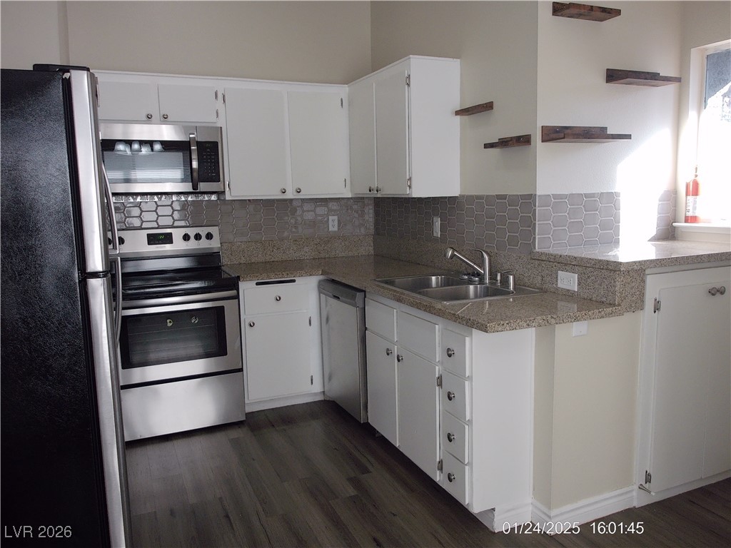 7313 Saybrook Point Drive Las Vegas, NV 89128 - Photo 13 of 31 Kitchen with appliances with stainless steel finishes, open shelves, white cabinetry, and tasteful backsplash
