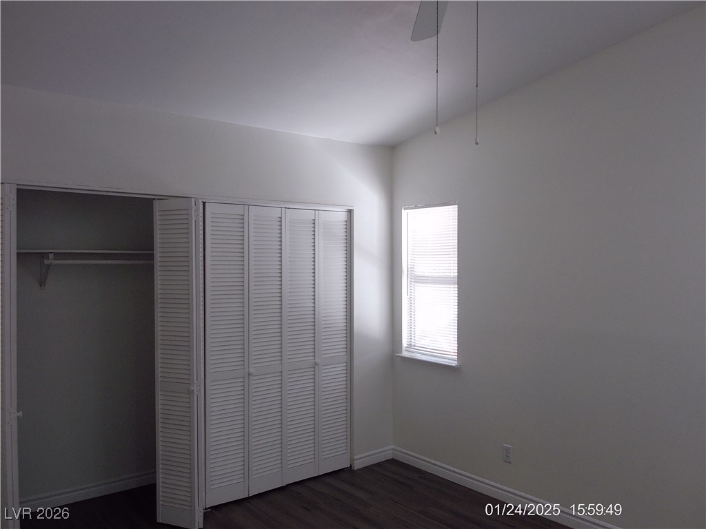 7313 Saybrook Point Drive Las Vegas, NV 89128 - Photo 14 of 31 Unfurnished bedroom featuring dark wood-type flooring, a closet, and a ceiling fan