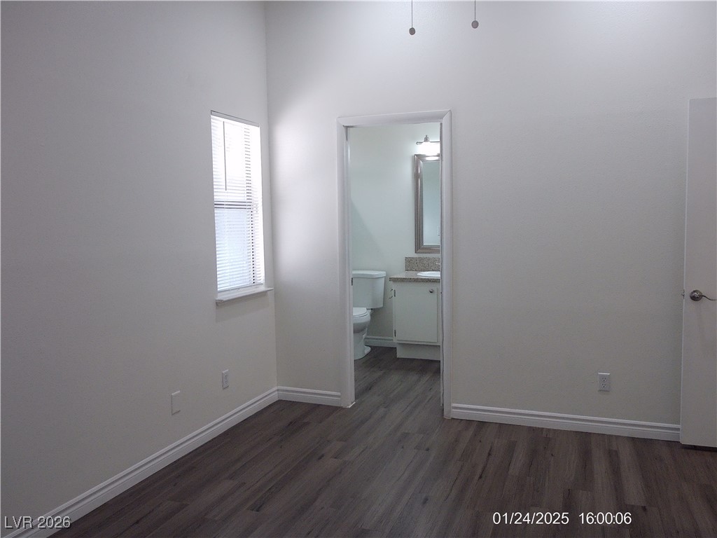 7313 Saybrook Point Drive Las Vegas, NV 89128 - Photo 15 of 31 Unfurnished bedroom featuring dark wood-style flooring and ensuite bathroom